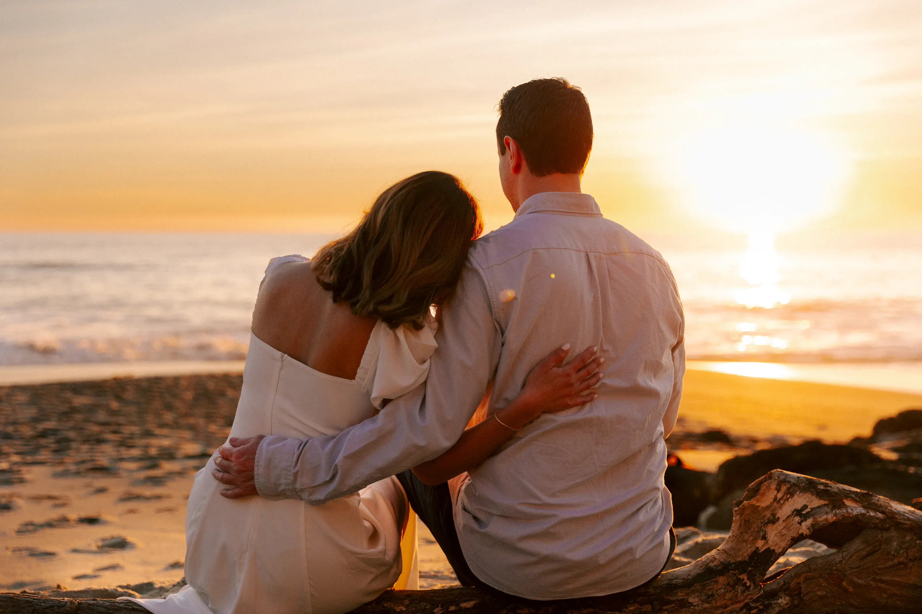 Couple embracing as the sun reaches the horizon