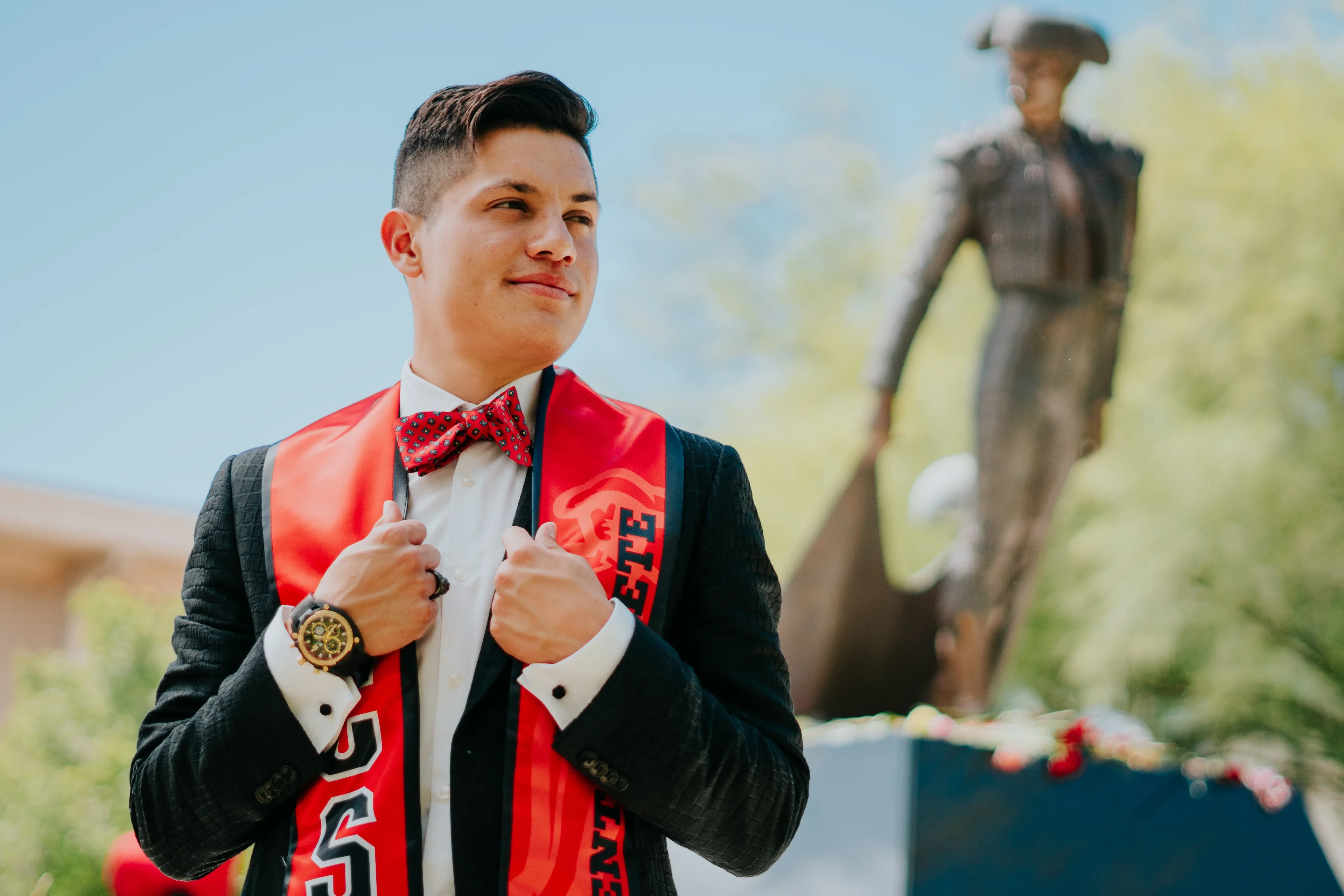 Cal State Fullerton graduate in cap, gown, cords, and red stole