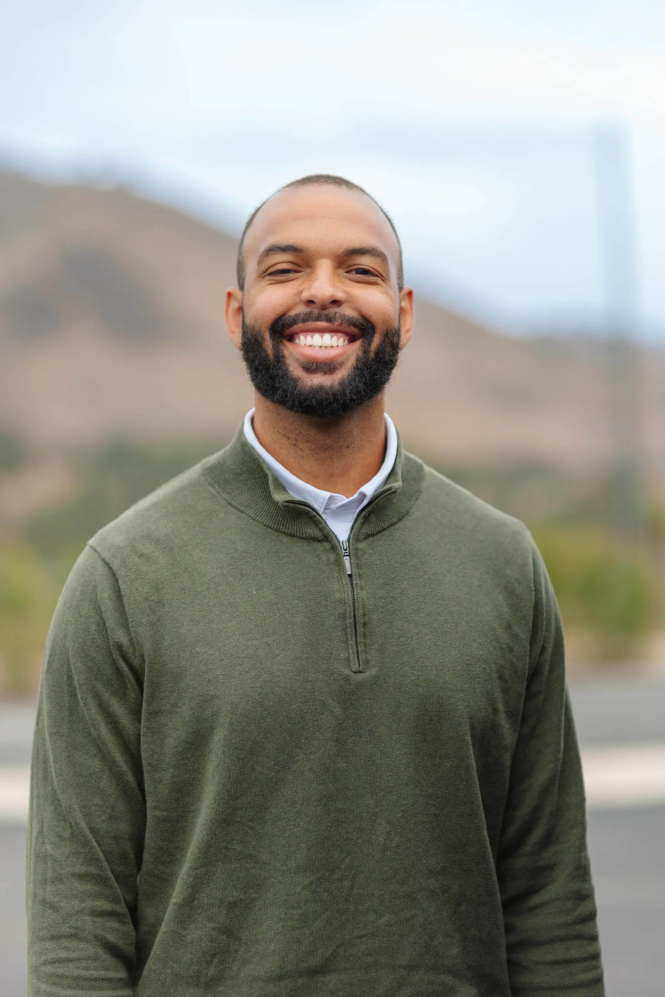 Environmental staff portrait with a softly blurred hillside background