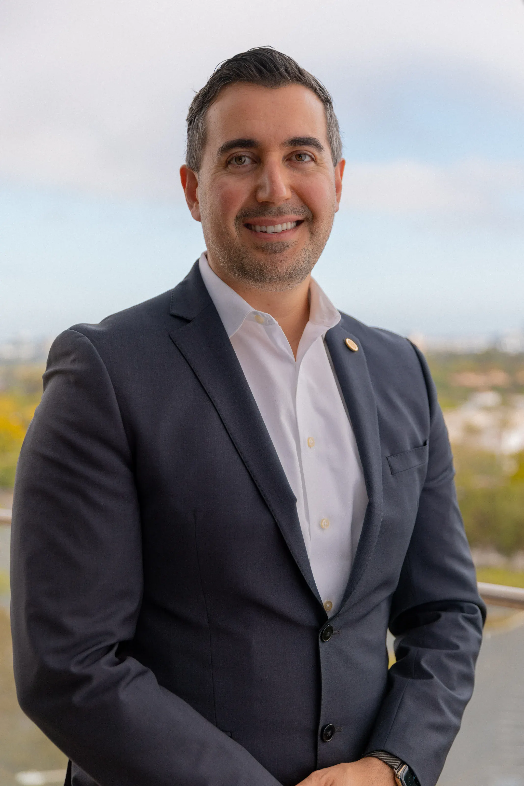 Professional portrait outdoors with a softly blurred campus background