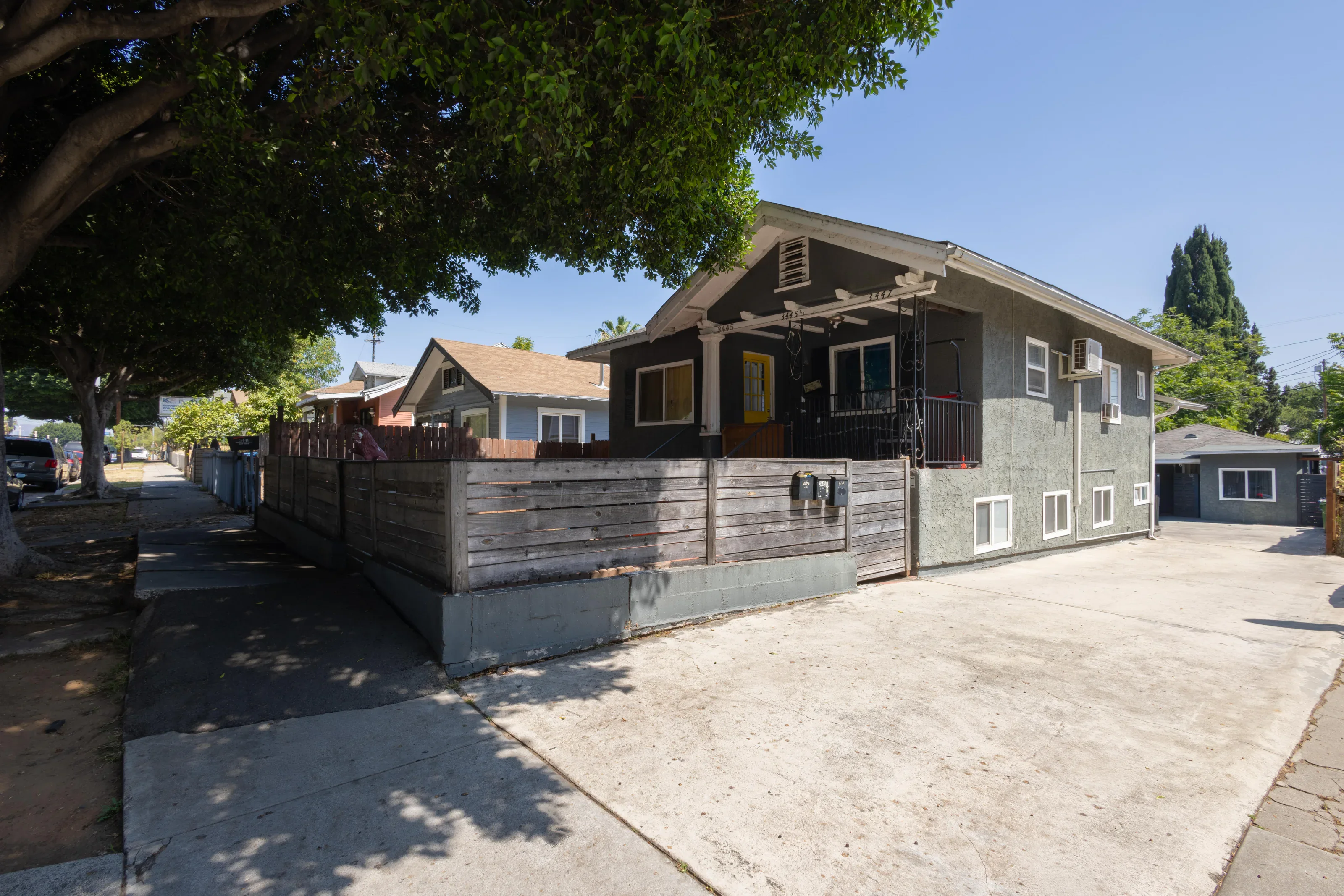 Wide exterior real estate photograph of a renovated multi-unit property
