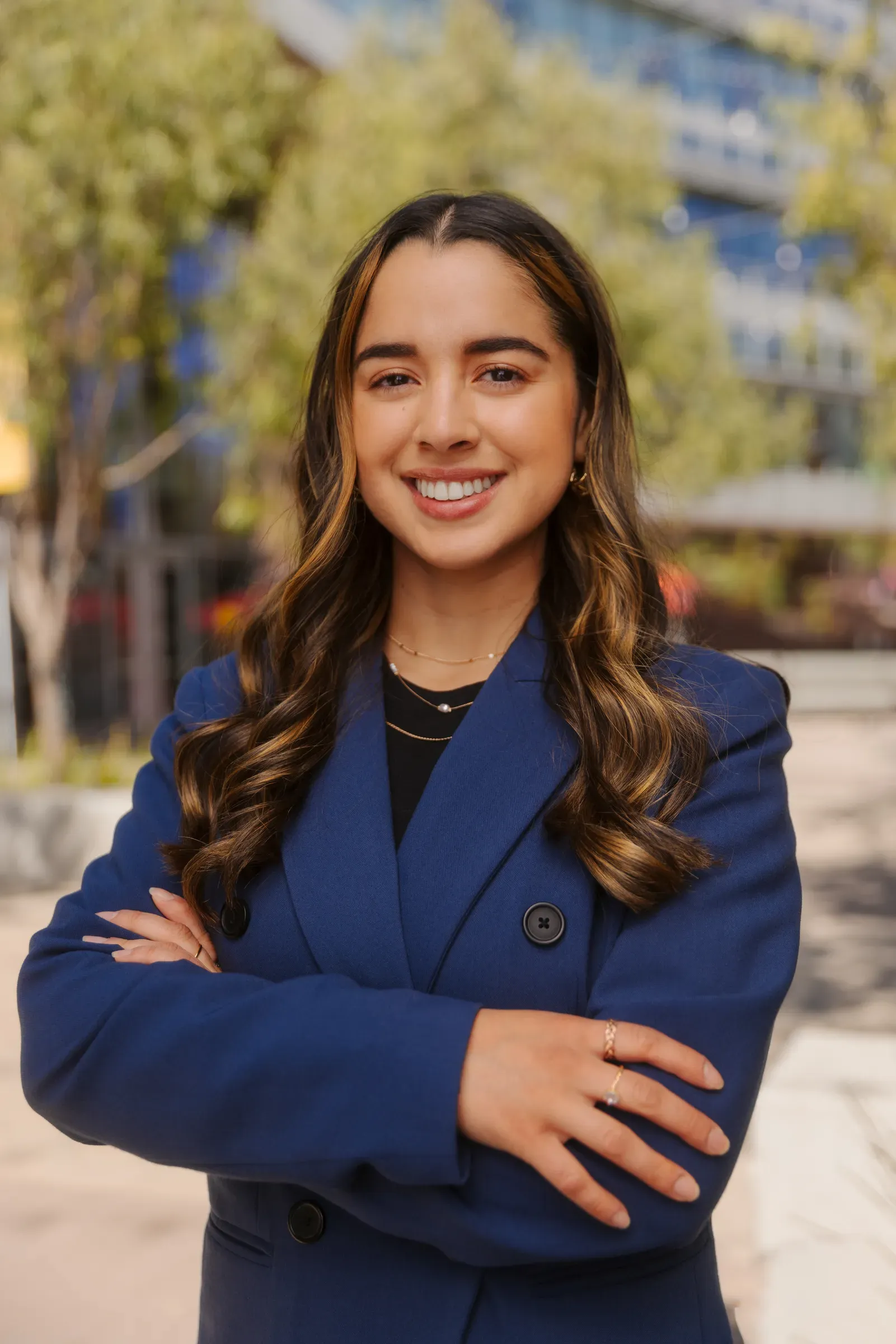 Professional portrait of a woman in a navy blazer, arms crossed