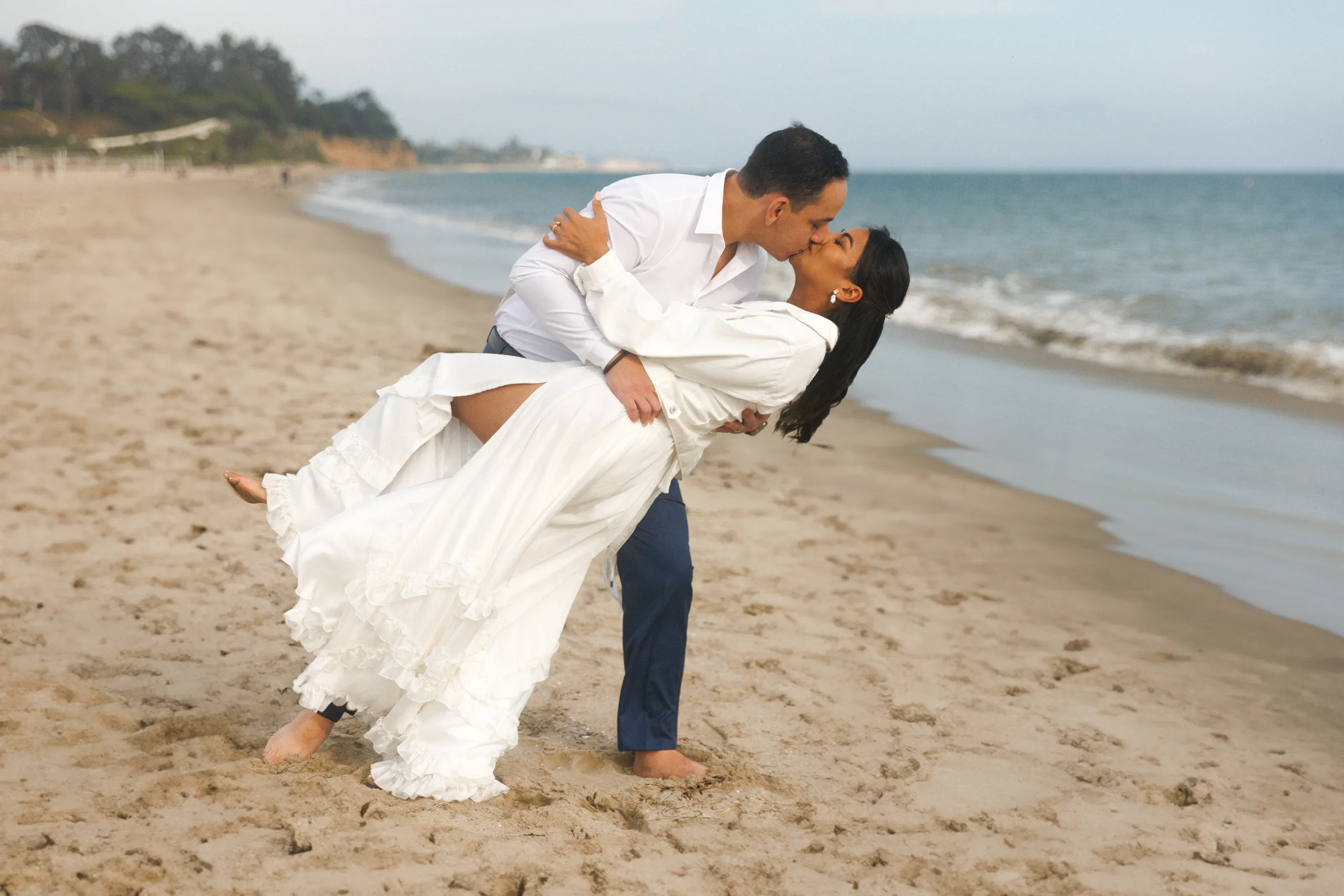 Playful newlywed portrait beside the ocean