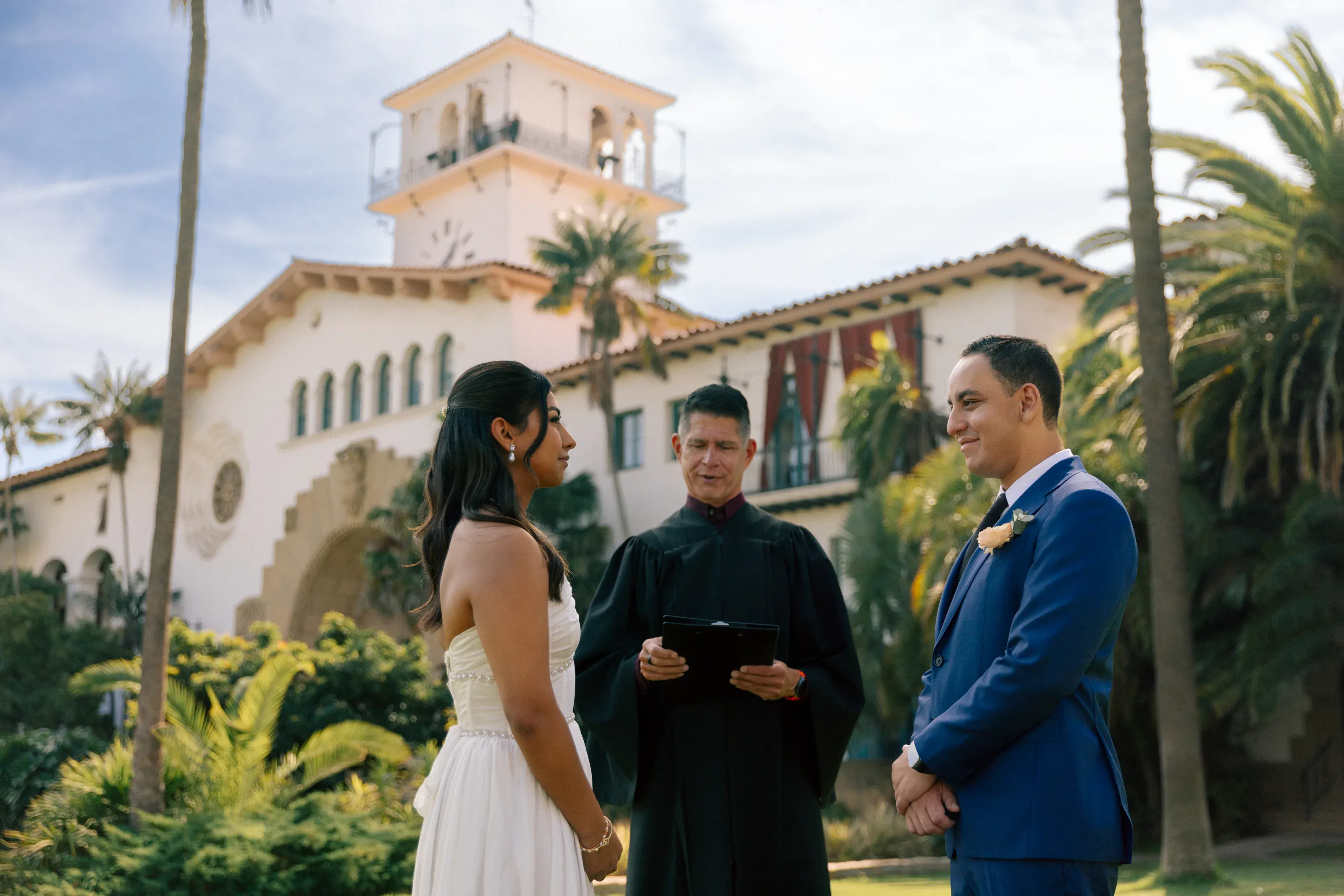 Wide ceremony moment with family and the Santa Barbara courthouse behind them