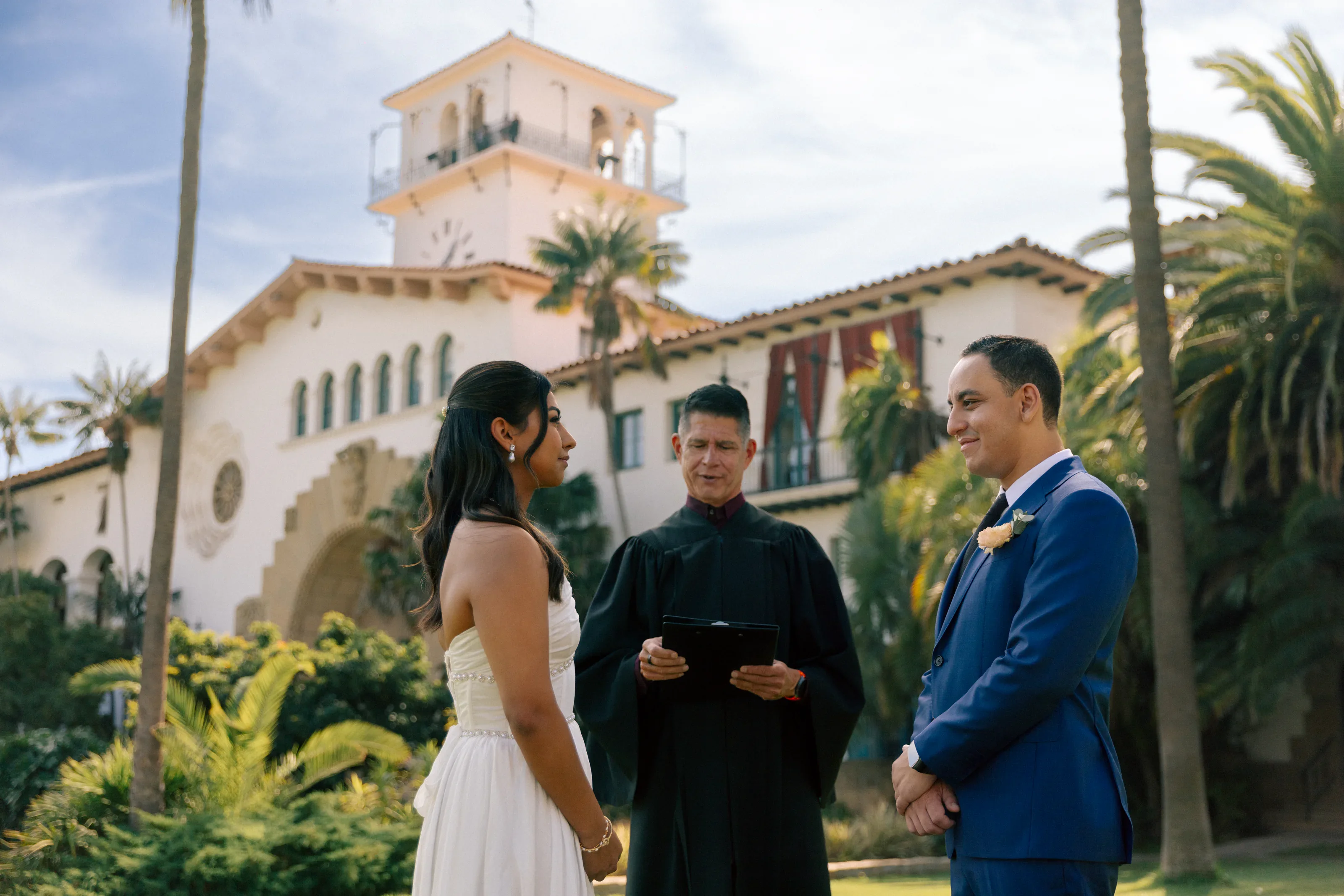 Wide ceremony moment with family and the Santa Barbara courthouse behind them